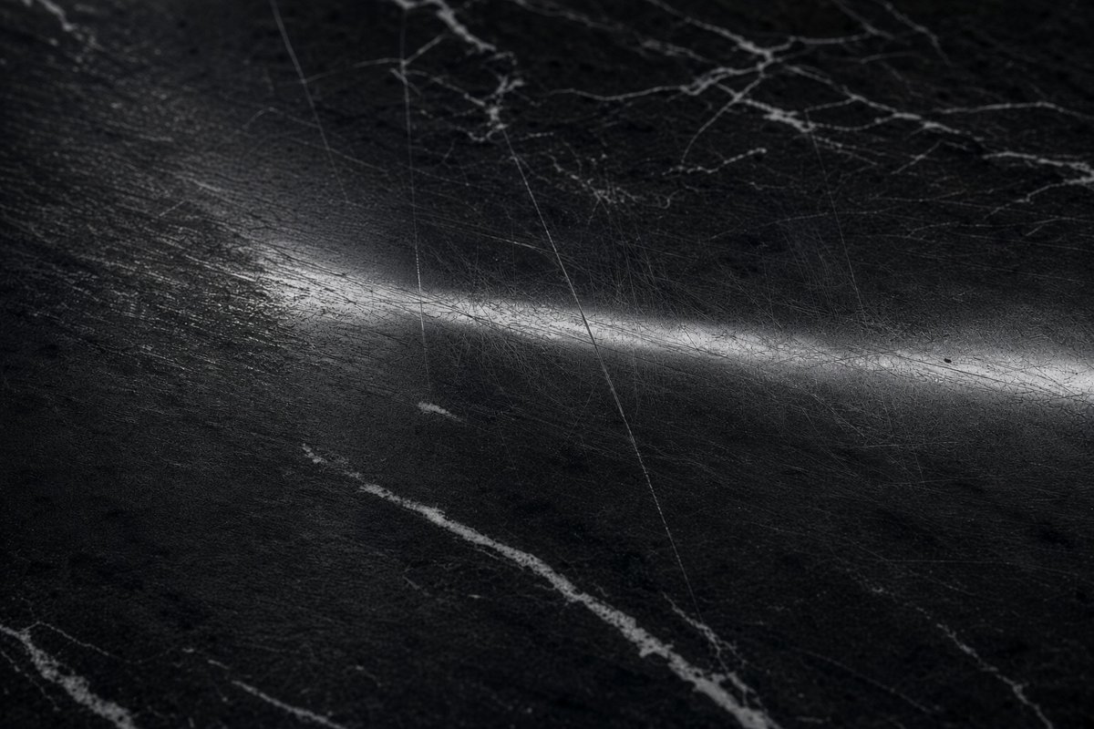 Close-up of scratched black marble with white veining