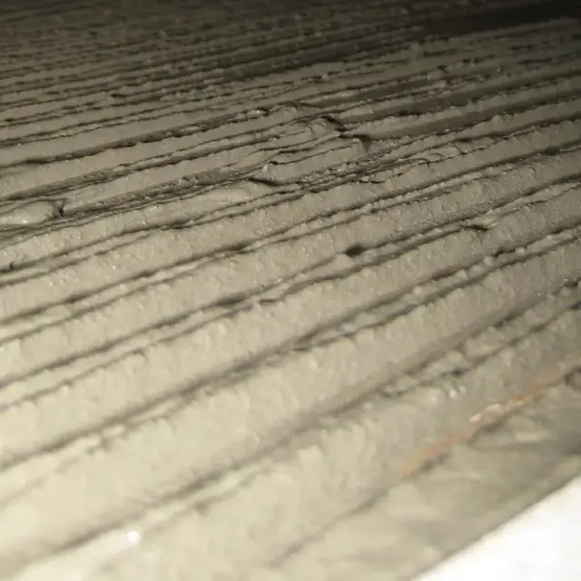 Real photo of thinset combed with a notched trowel into straight ridges